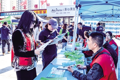 活動現(xiàn)場，居民圍在招聘展板前仔細查看崗位信息。韓堃攝